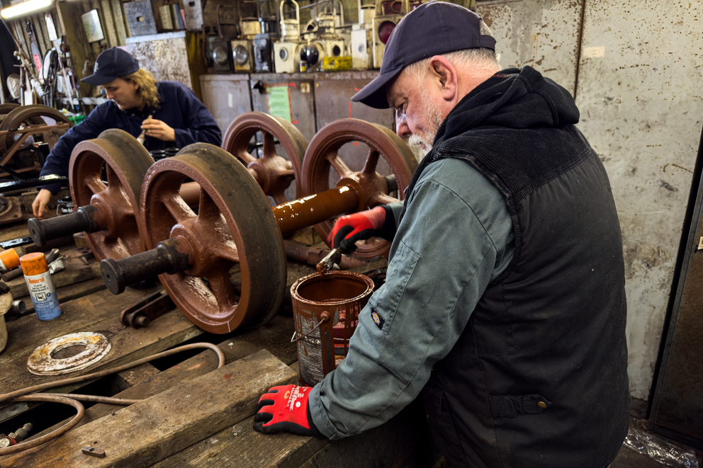 Volunteers painting the wheels for the restored Van 23 - 3 December 2024