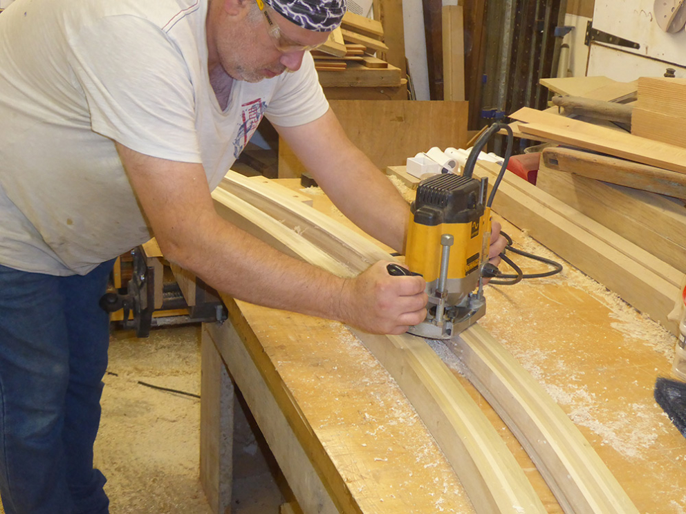Dave Ely can be seen routing one of the roof beams